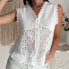 White lace-trimmed blouse worn by a person, with a neutral background.
