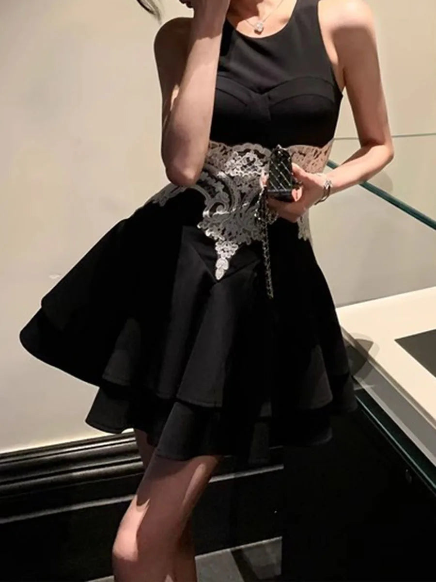 Black dress with lace detailing worn by a person indoors.