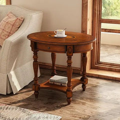 Wooden side table with a cup and saucer next to a sofa in a room with large windows.