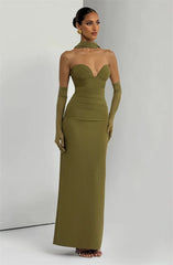 Woman wearing a green strapless gown with matching gloves against a white background