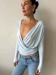 Model wearing plunge neckline wrap crop top with jeans