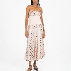 Woman wearing a strapless dress with polka dot top and skirt on a white background