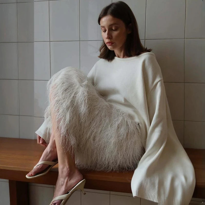 Woman sitting on a wooden bench with a fluffy white bag against a tiled wall.