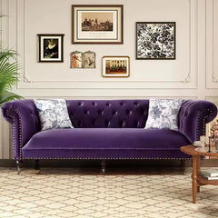 Tufted velvet purple sofa styled in classic living room with art wall