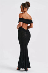 Woman wearing a black off-shoulder lace dress on a white background