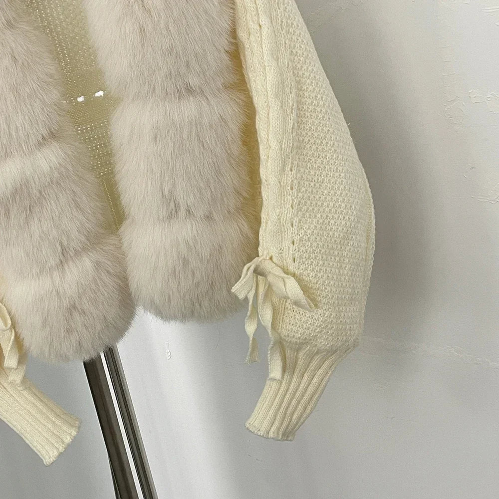 Close-up of a cream-colored fur coat with ribbed sleeves on a stand.