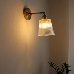Wall-mounted lamp with ribbed glass shade on a plain wall