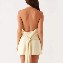 Woman wearing a light yellow dress with a backless design on a white background