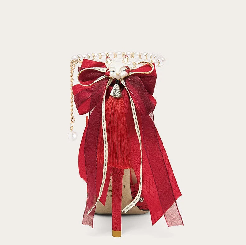 Decorative red bow with tassels on a white background