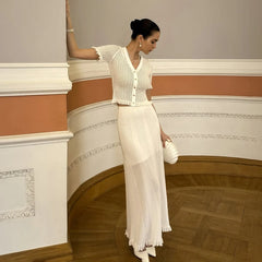 Woman in a white dress standing in an elegant interior setting