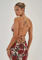 A woman wearing a red floral print maxi dress with a cowl neckline and tie-back detail. Golden Atelier 4