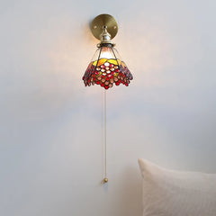 Wall-mounted lamp with stained glass shade on a plain wall