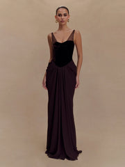 Woman wearing a long, dark brown evening gown against a beige background