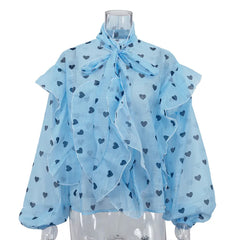 Light blue blouse with heart patterns on a mannequin against a white background