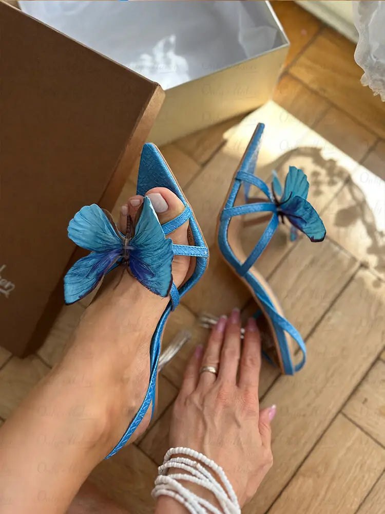 Butterfly strap clear heel sandals on a foot