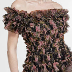 Close-up of a ruffled, off-shoulder dress with a floral pattern 
