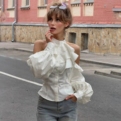 Close-up of white ruffled cold shoulder puff sleeve blouse