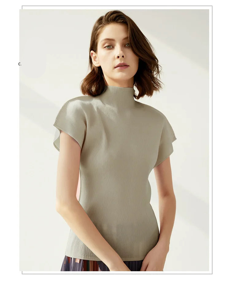 Woman wearing a light green turtleneck sweater on a plain background