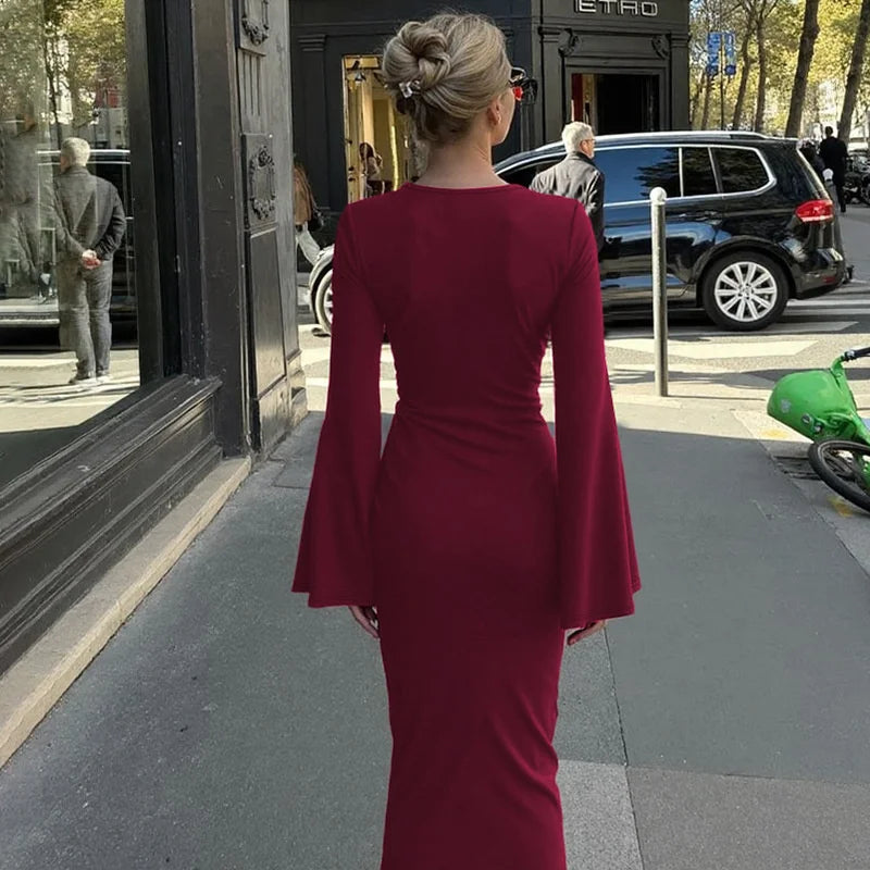 Woman in a burgundy dress walking on a city street.