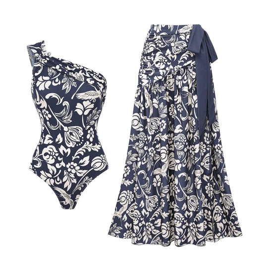 Navy and white print one-shoulder swimsuit top and matching maxi skirt laid out.
