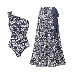 Navy and white print one-shoulder swimsuit top and matching maxi skirt laid out.