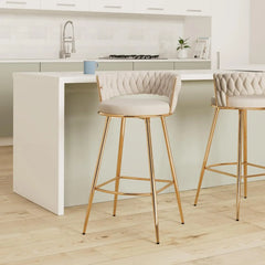 Two bar stools with gold legs and beige cushioned seats in a kitchen setting.