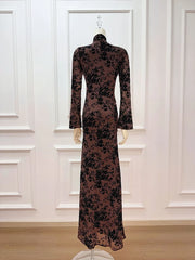 Long floral dress on a mannequin against a white paneled wall.