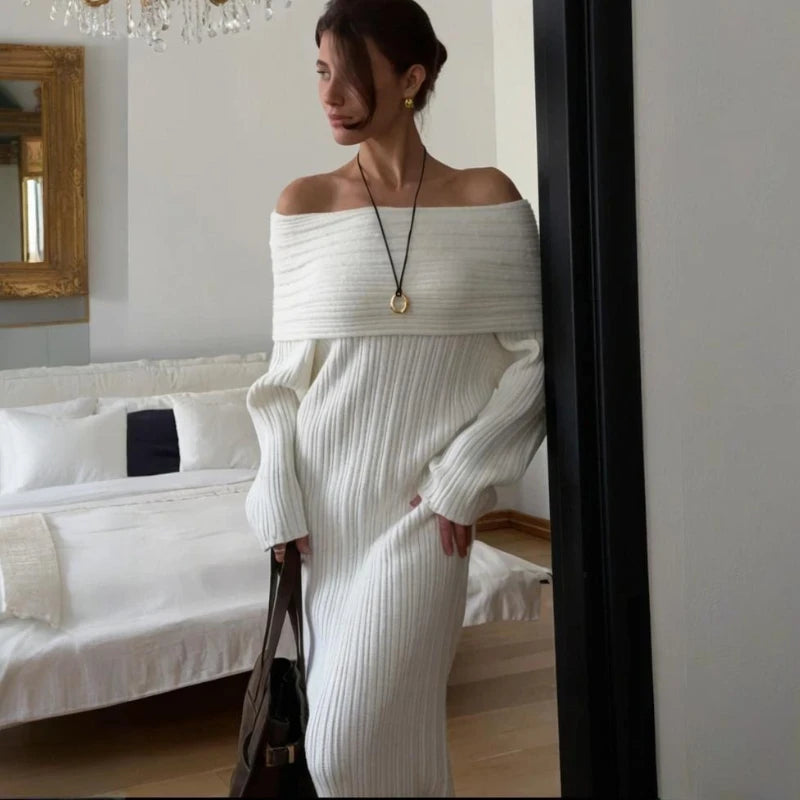 Woman wearing a white off-shoulder sweater in a room with a mirror and sofa.