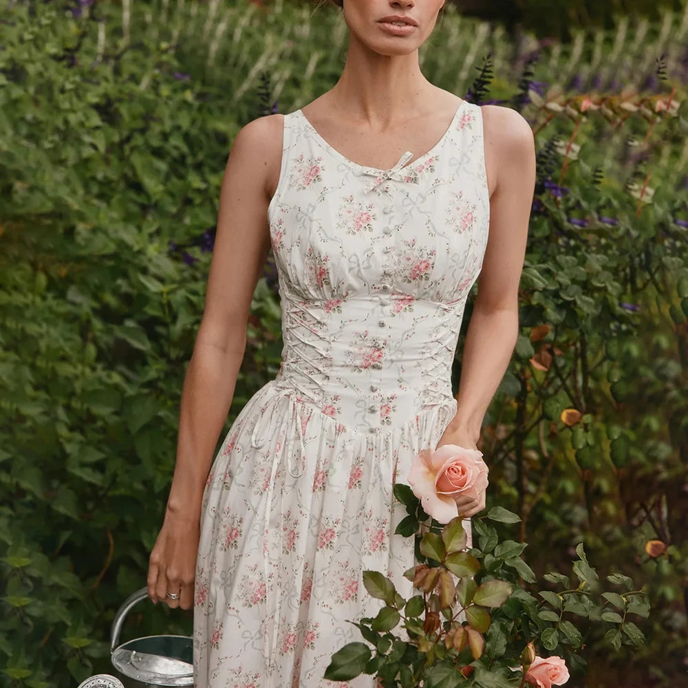 Woman in a floral dress holding flowers in a garden setting
