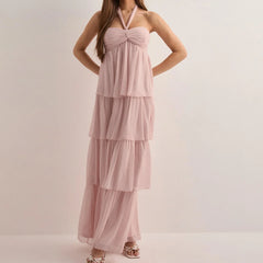 Pink tiered dress worn by a model on a plain background