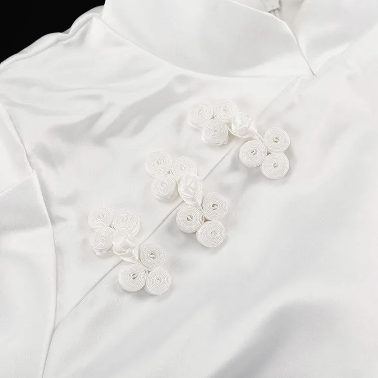White blouse with floral button details on a white background