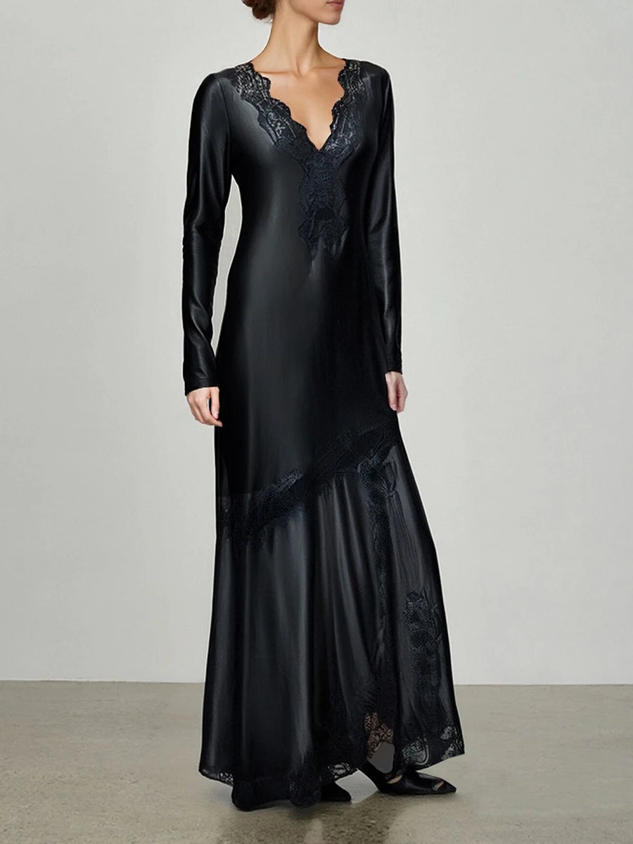 Black satin evening gown with lace details on a plain background
