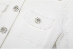 Close-up of white knit cardigan pocket and crystal button