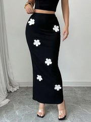 Black skirt with white floral patterns worn by a person indoors.