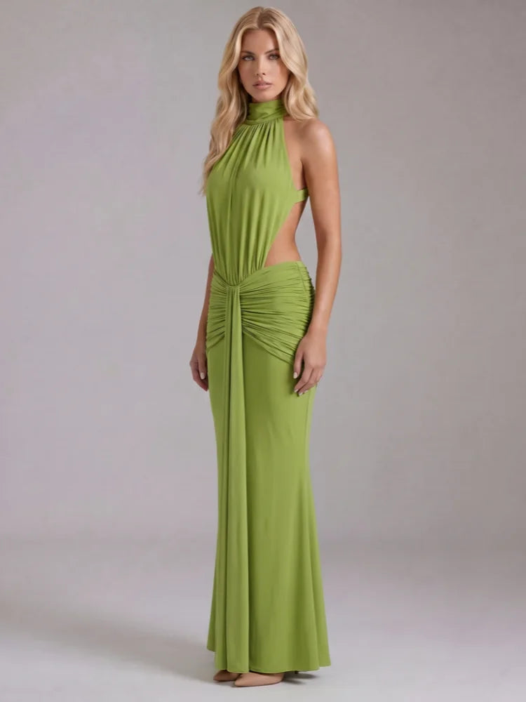 Side profile of a woman in a green halter neck draped maxi dress.