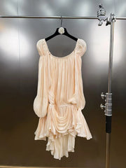 Beige dress hanging on a rack against a metallic background