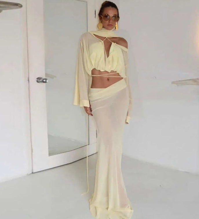 Woman in a light-colored outfit standing in a minimalistic room.