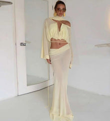 Woman in a light-colored outfit standing in a minimalistic room.