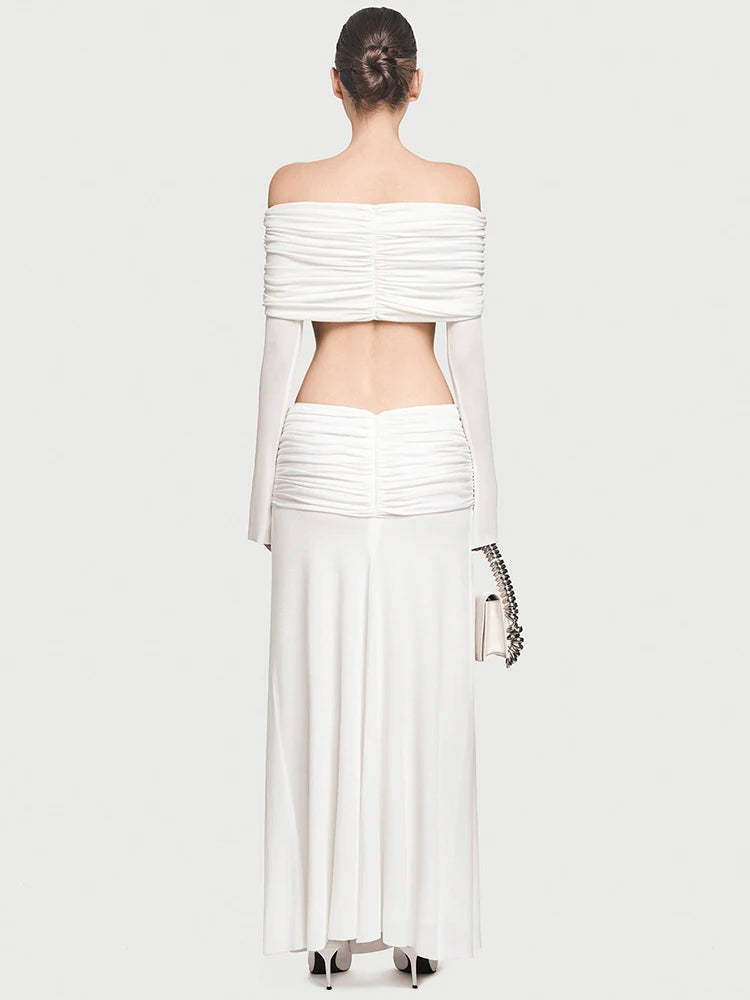 Woman wearing a white off-shoulder top and skirt set on a plain background