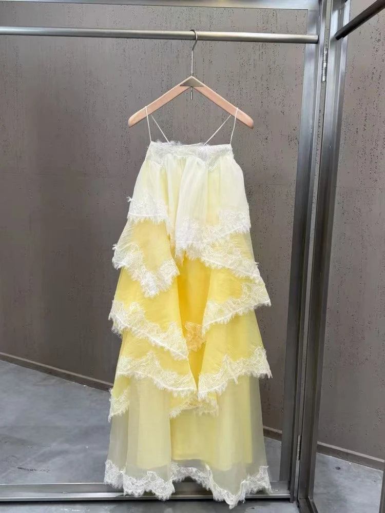 Yellow lace dress on a hanger against a neutral background