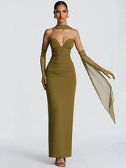 Woman wearing a green strapless gown with long gloves on a white background