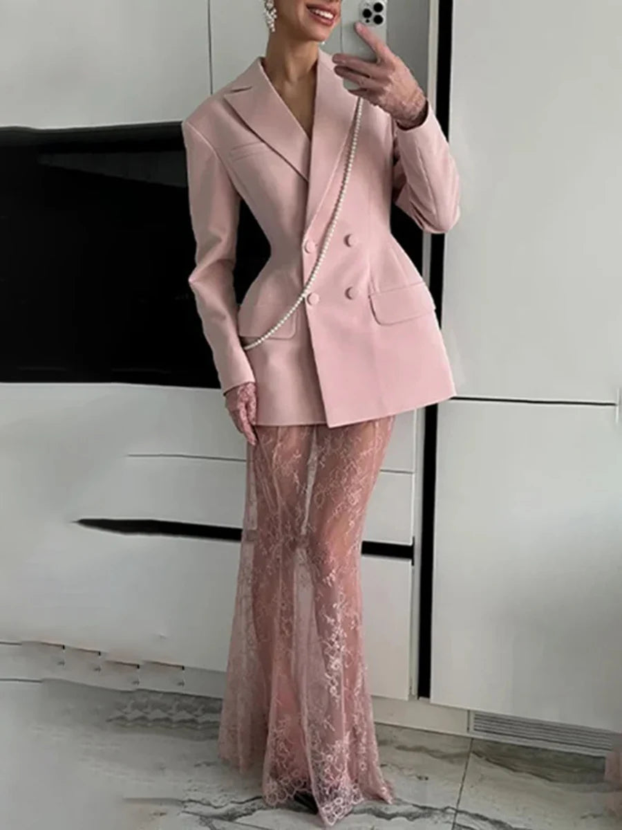 Person wearing a pink suit with a sheer pink skirt in an indoor setting.
