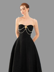Woman wearing a black evening gown with pearl details