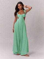 Woman wearing a mint green strapless  jumpsuit against a plain background