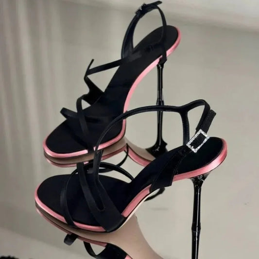 Pair of black stiletto strap sandals with pink trim