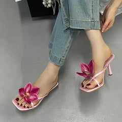 Model wearing pink floral embellished square toe heeled mules