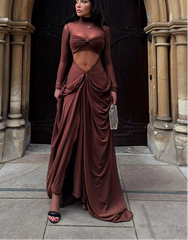 Woman in a burgundy evening gown standing in front of an archway.