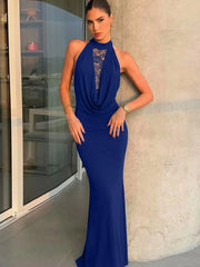 Woman wearing a blue evening gown with a lace neckline in an indoor setting.