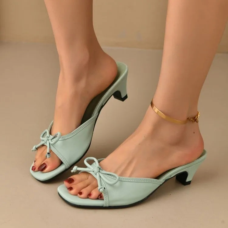 Light blue high-heeled shoes worn by a person on a beige background