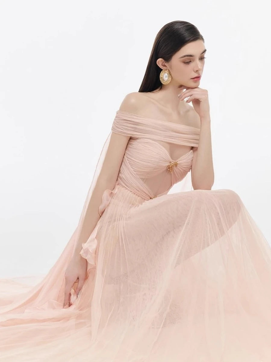 Woman wearing a pink off-shoulder gown with a white background